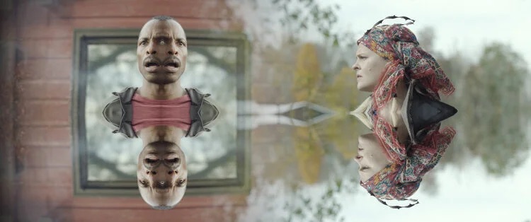 Two mirrored faces on either side of a misty lake